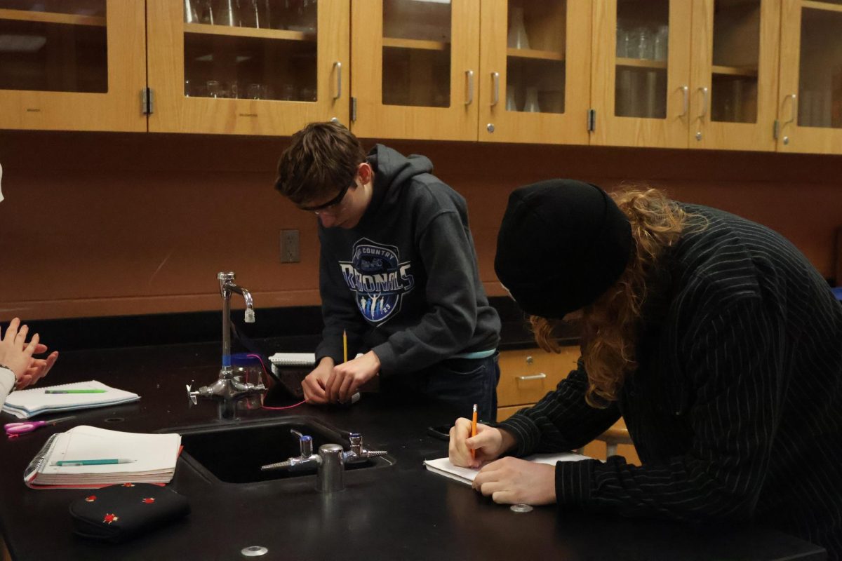 Recording data, seniors Anthony Maini and Logan Young participate in a physics lab. On March 5, science teacher Nicholaus Jeffrey held a lab in his 4th hour physics class.