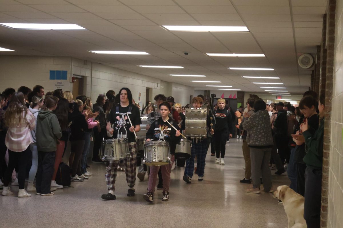 Marching, the fenton drumline plays as they escort out the wrestling and bowling team to states. On Feb. 29th, the students gather around to congratulate them. 