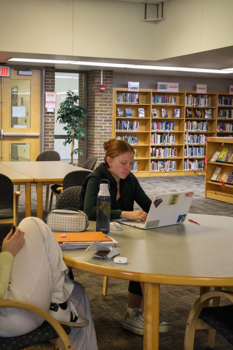 Studying, Seinor Nina Frost completes homework during lunch. On March 13th, students sat in the media center to work.