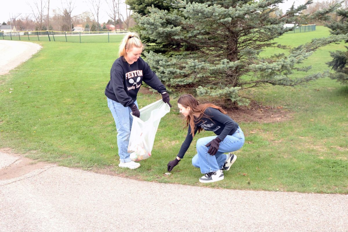 Picking up trash, senior Carli Best and junior Gwen Grove participate in the campus clean-up. On. Apr 18th, ECO Club held a campus clean-up outside of the FHS.