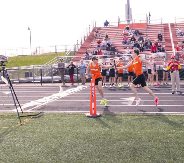 Running, freshmen Grant Hunault hands the baton off to senior Anthony Maini. On April 10, the boys track team went up against Linden winning 96-41. 