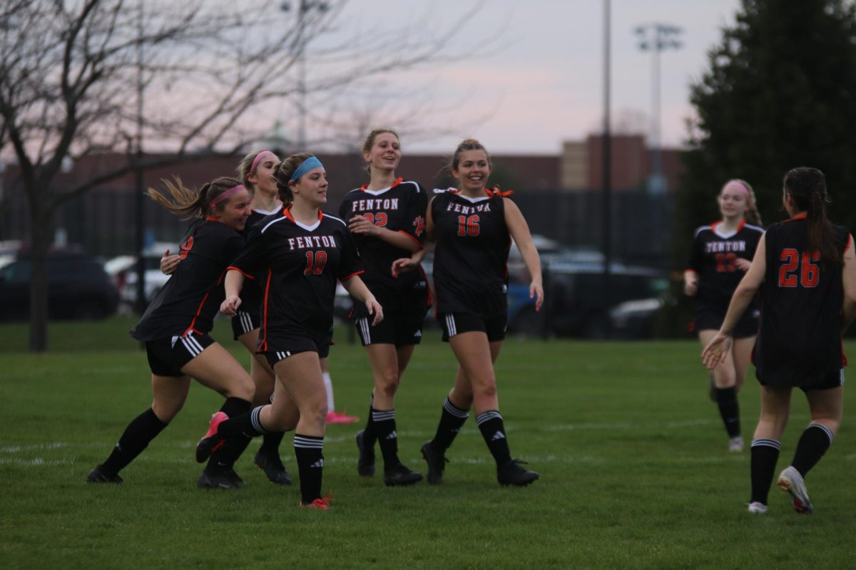 Cheering for her team goal, junior Maddie Sheffield celebrates her teammates goal. On April. 10, the varsity Fenton girls soccer team tied with Holly 1-1