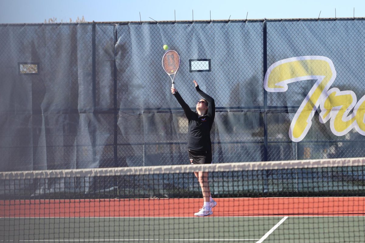 Serving, freshman Isla Decker hits the ball on to the court. On April 25, Fenton varsity tennis traveled to Owosso and lost 2-5.