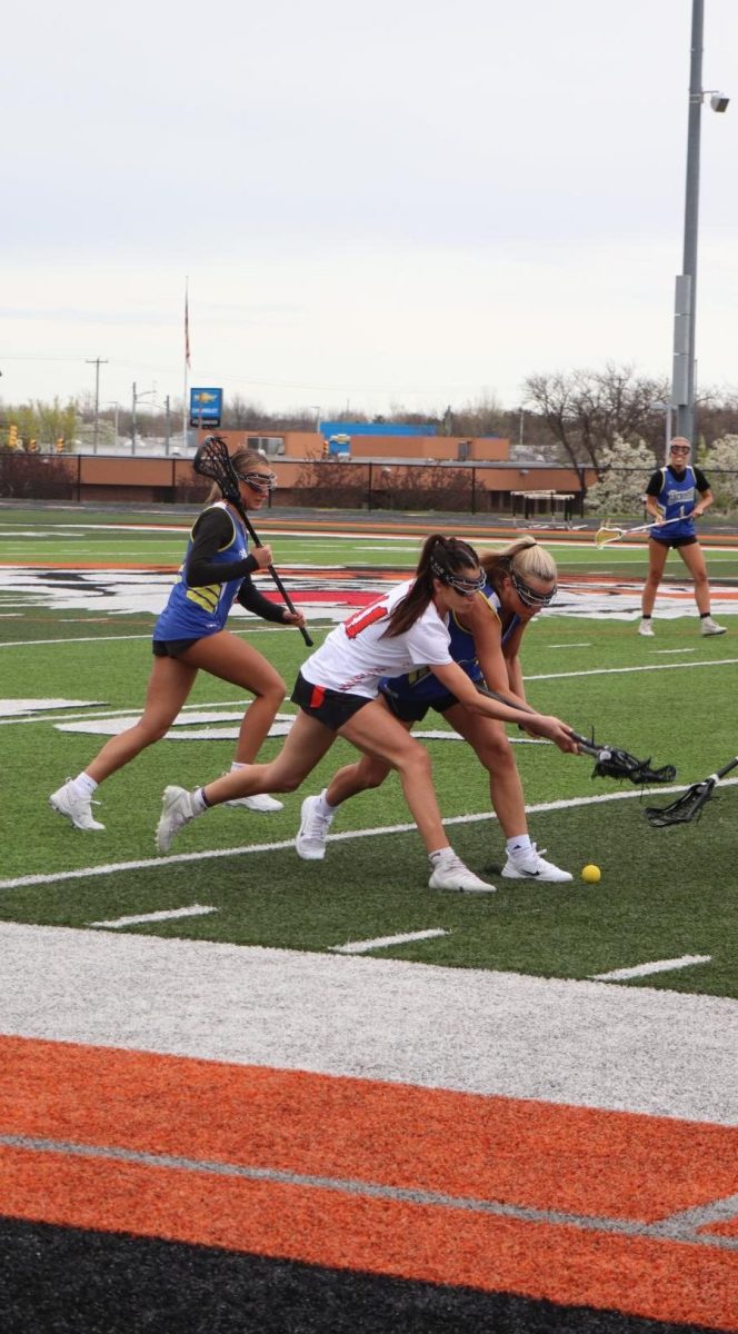 Focusing+on+the+ball%2C+Junior+Blaze+Hessling+scoops+a+ground+ball.+On+Apr.+18%2C+the+varsity+lacrosse+team+played+LFG+and+won+with+a+score+of+9-7.
