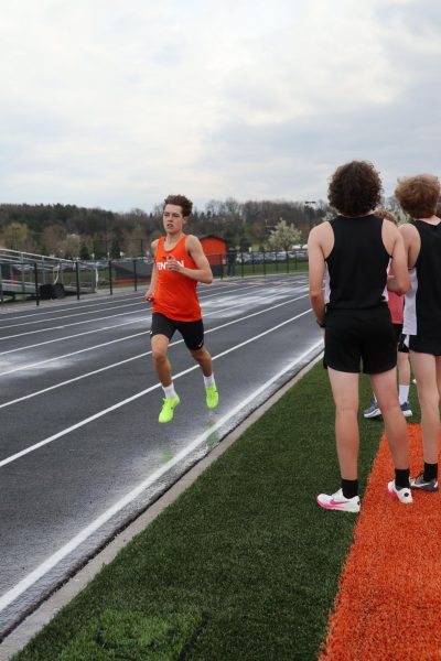 Running, sophomore Dillon Hamilton gets cheered on by his teammates. On April 17th the track team won against Swartz creek 121 - 15.