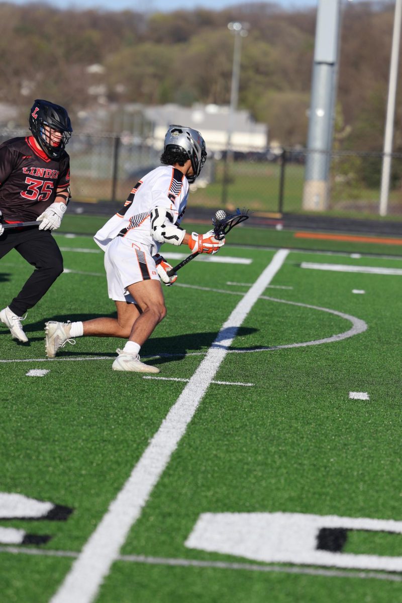 Running with the ball, senior Hougen Vaughn attempts to juke out the defender. On April 19, the FHS varsity boys lacrosse team went against Linden winning 17 to 3.