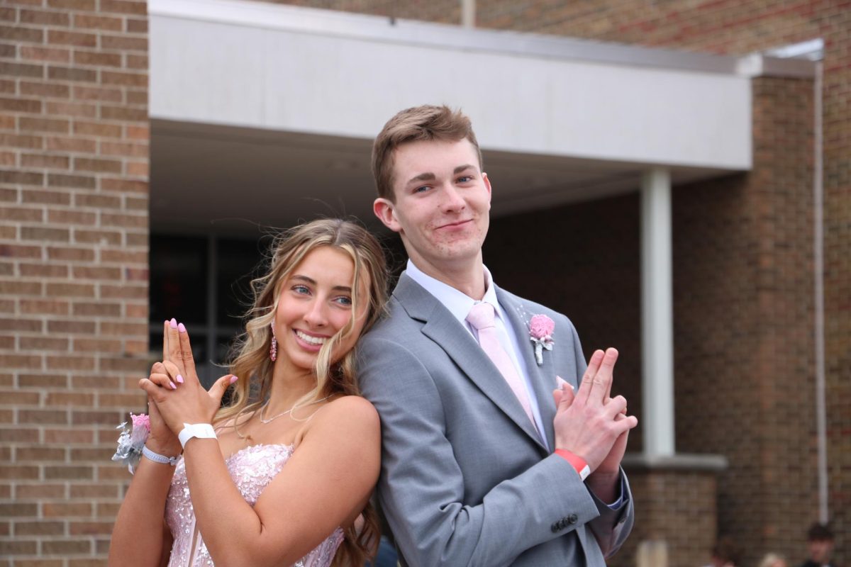 Posing, seniors Henley Barz and Gibson Lehmann model for the camera. On Apr. 20, students gather to walk the red carpet on their way to prom. 