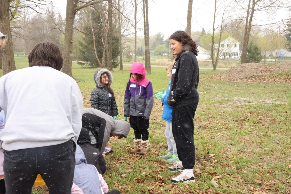 Instructing a game, junior Anna Logan helps teach students about wildlife in the pond. On April 24, the IB Biology students held an instructional pond day for the elementary students.
