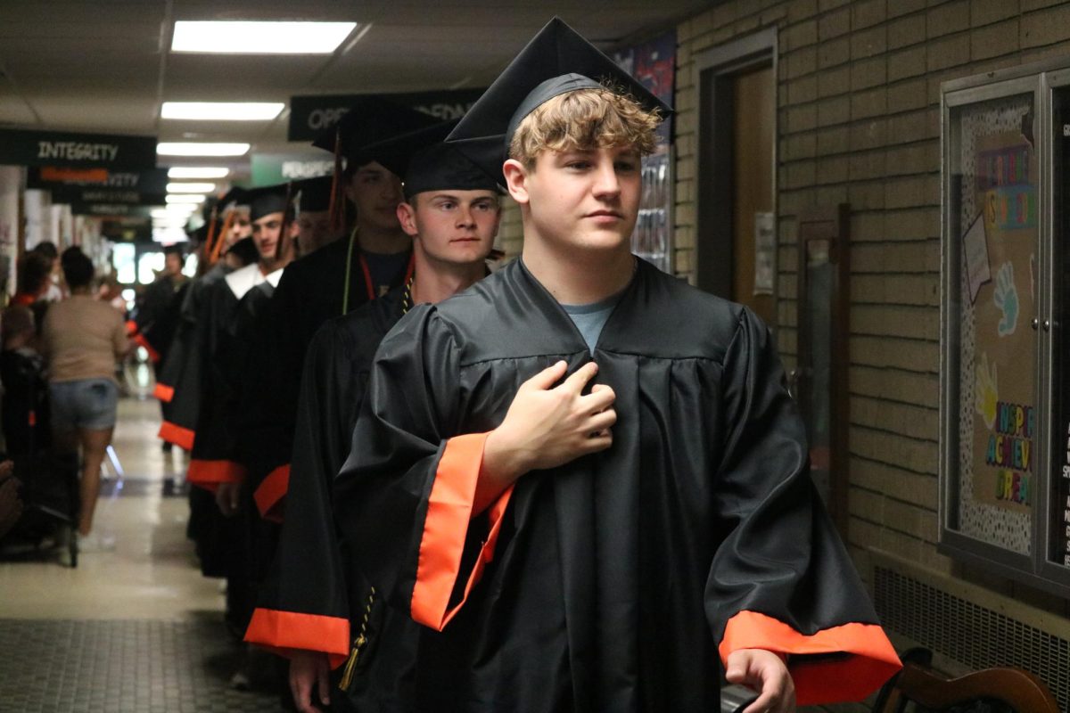 Staring proud, senior Cameron Dean high fives kids. On May 22, the seniors walked the State Road halls for the clap out. 