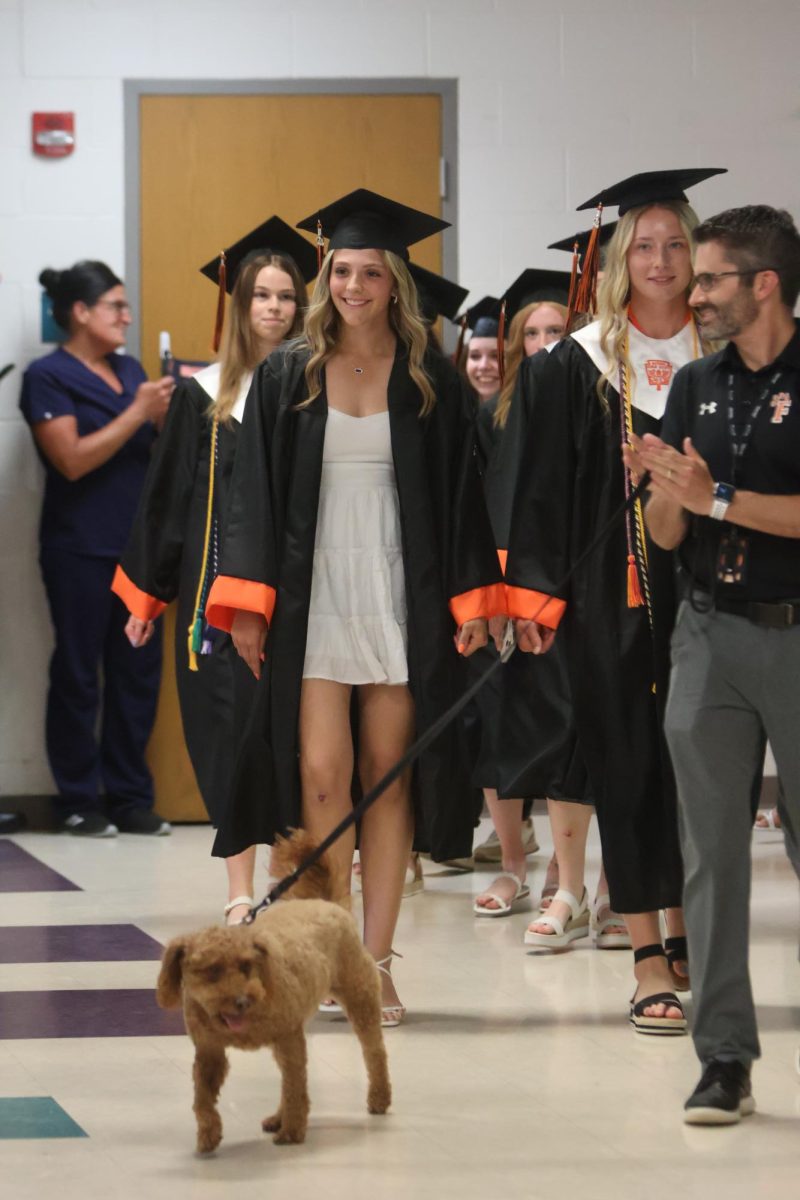 Smiling, senior Kariana Pelkey walks through State Road. On May 22, the senior graduate class walked through their elementary school for the last time. 