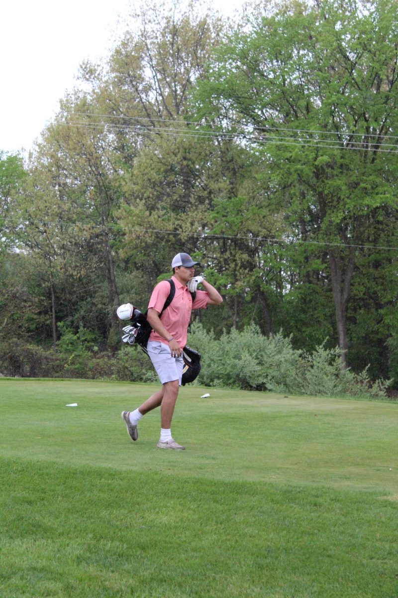 Walking, junior Tyler Moorse carries his equipment to the next hole. On May 7, Fenton played against Lake Fenton.