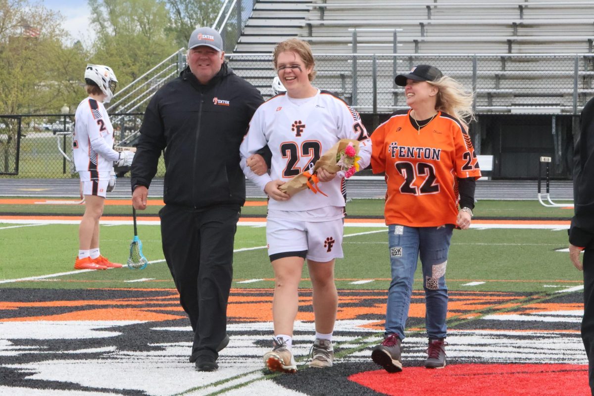 Walking, senior captain Vaughn House is escorted down the tunnel by his mom and dad. On May 11, the Fenton lacrosse team held their senior night to honor the graduating class.