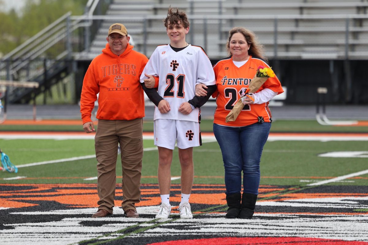 Smiling, senior Caleb Walker poses with his parents. On May 11, the FHS varsity lacrosse team celebrated senior night.
