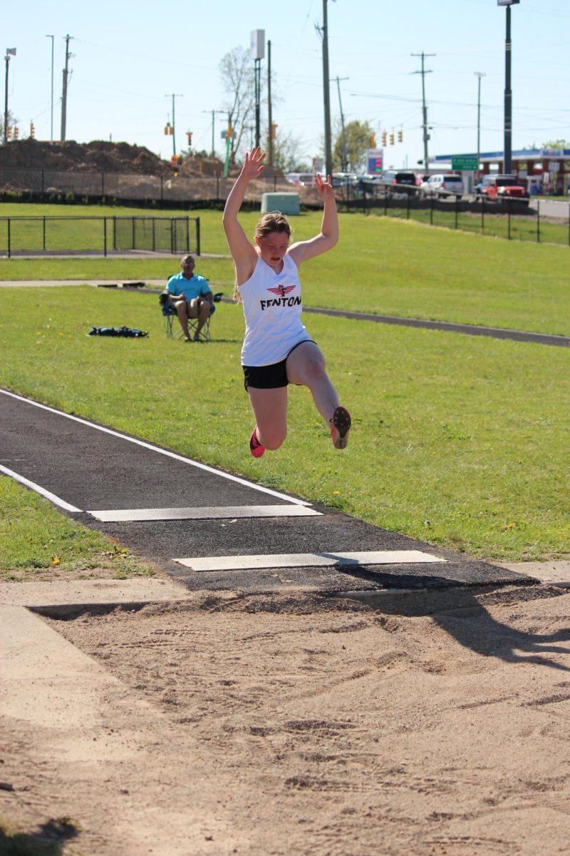 Jumping, freshman Sophia Davidson competes in long jump. On May. 2, Fenton girls track played against Holly and won. 