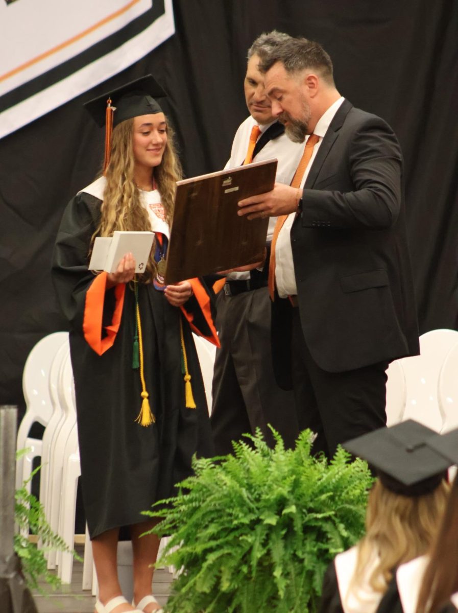 Standing, senior Tori Henson receives an award. On May 22, the seniors gathered in the gym for the honors assembly. 