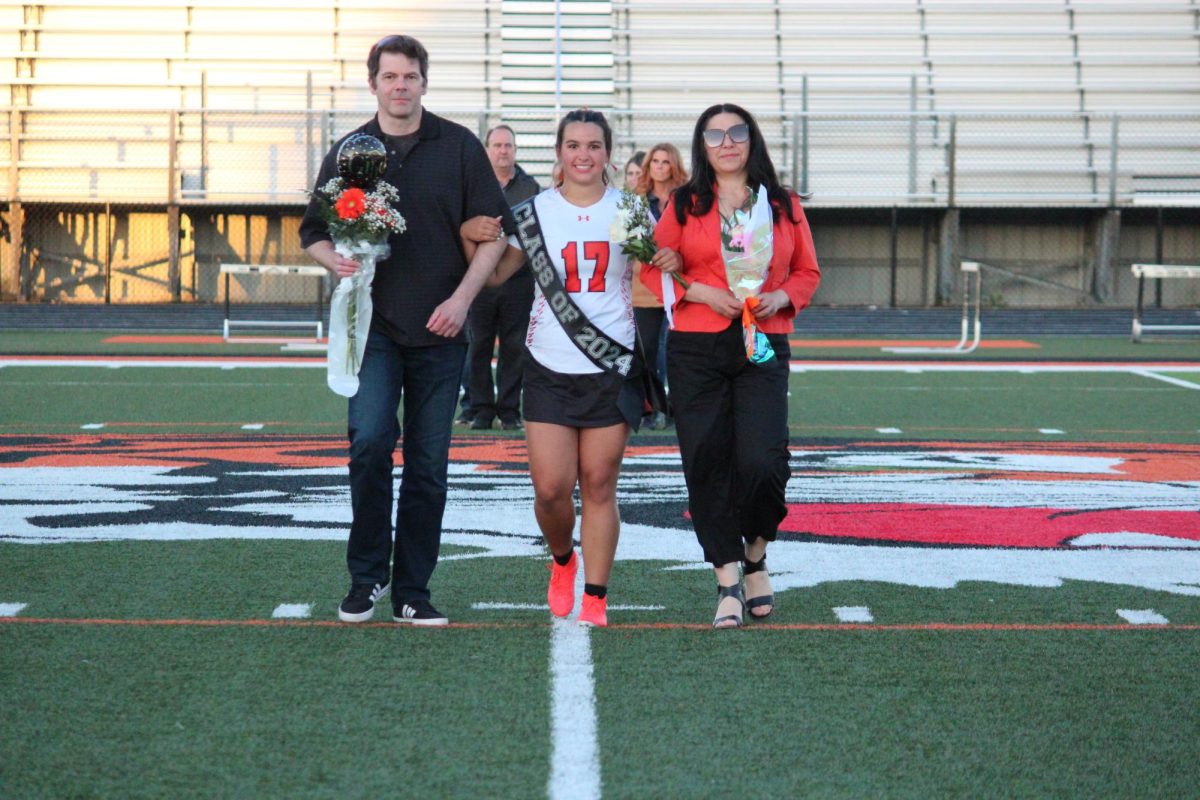 Walking, senior Sara Kanaski plays lacrosse. On May. 6, girls varsity lacrosse had their senior night.