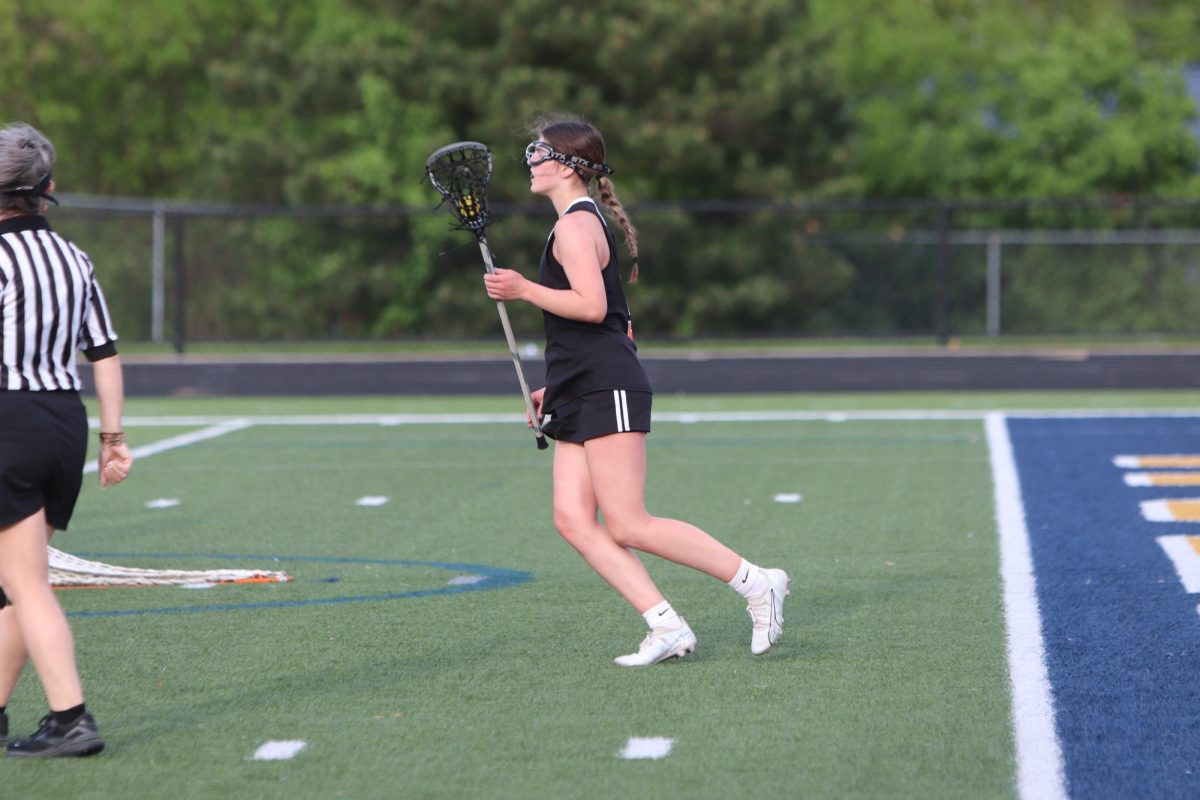 Looking for a pass, sophomore Eviana Fulton cradles the ball while running up the field. On May 13, The Fenton/Linden Heat girls lacrosse team played Clarkston and tied.