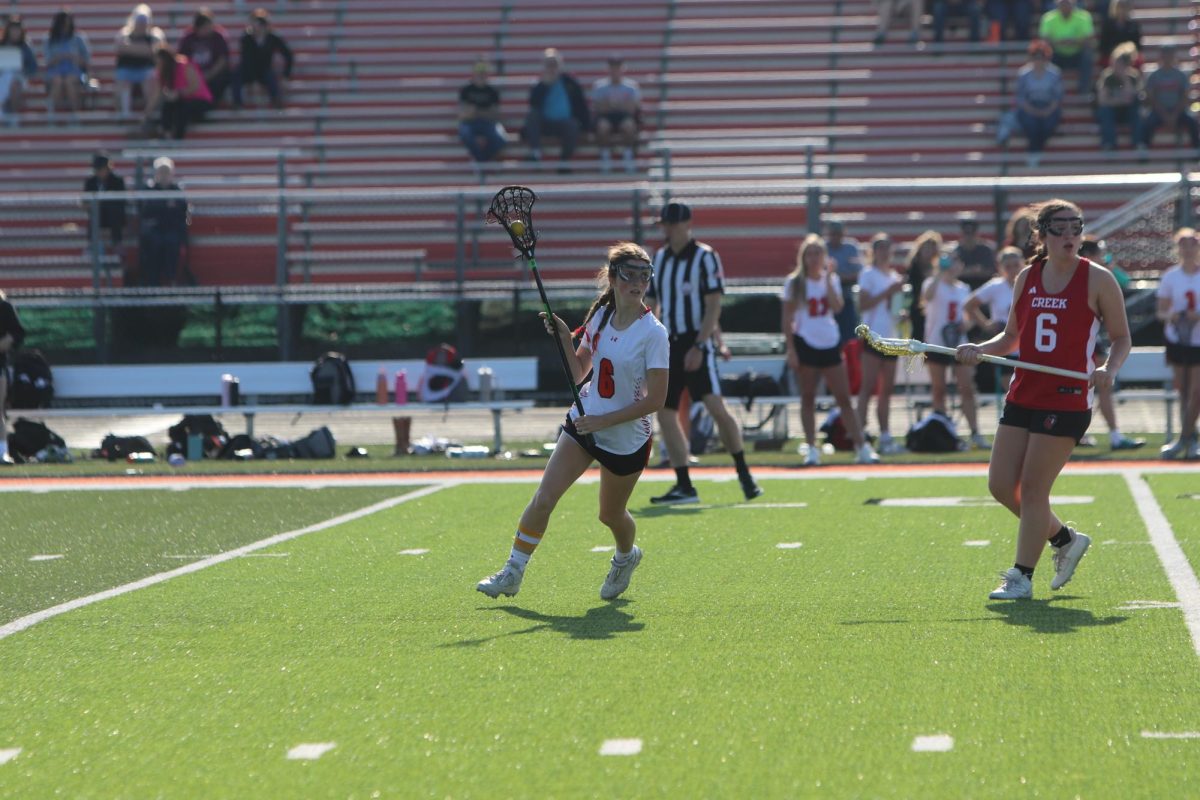 Cradling the ball, junior Paige Harrison runs up the field looking to score a goal. On May 15, the varsity Fenton Linden Heat girls lacrosse team played Swartz Creek and lost 12-8.