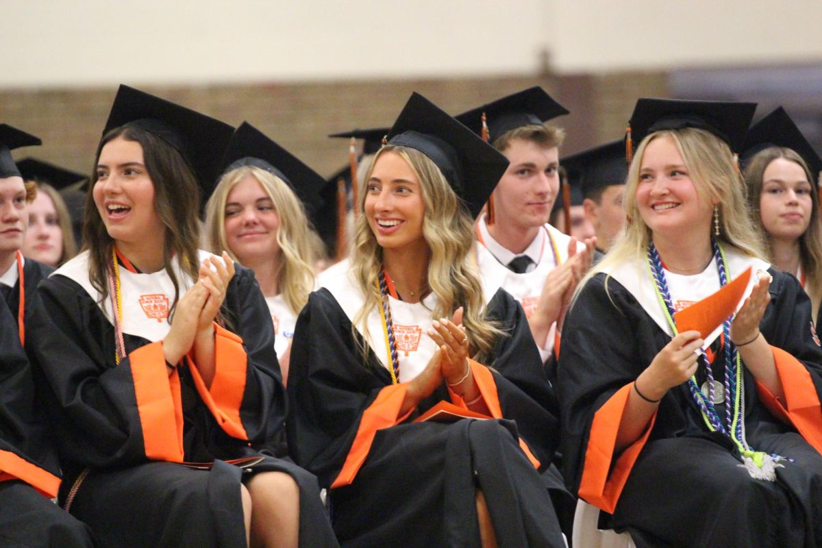 Clapping%2C+seniors+Paige+Bakker%2C+Henley+Barz%2C+and+Carli+Best+applaud++the+speeches.+On+May+23.+graduation+took+place+in+the+gym.++