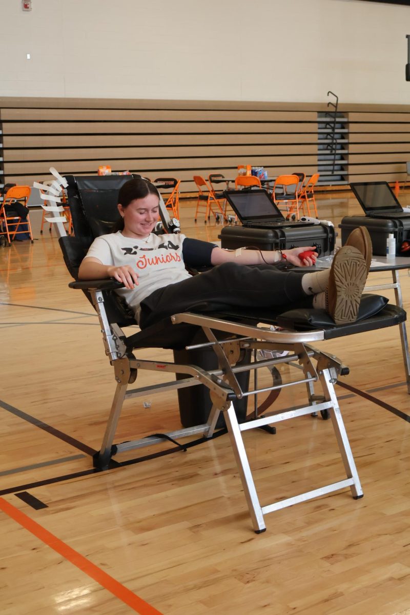 Smiling, senior Allie Michewicz closes her eyes as she gives blood. On Apr. 26, Fenton High School held its last blood drive of the year.