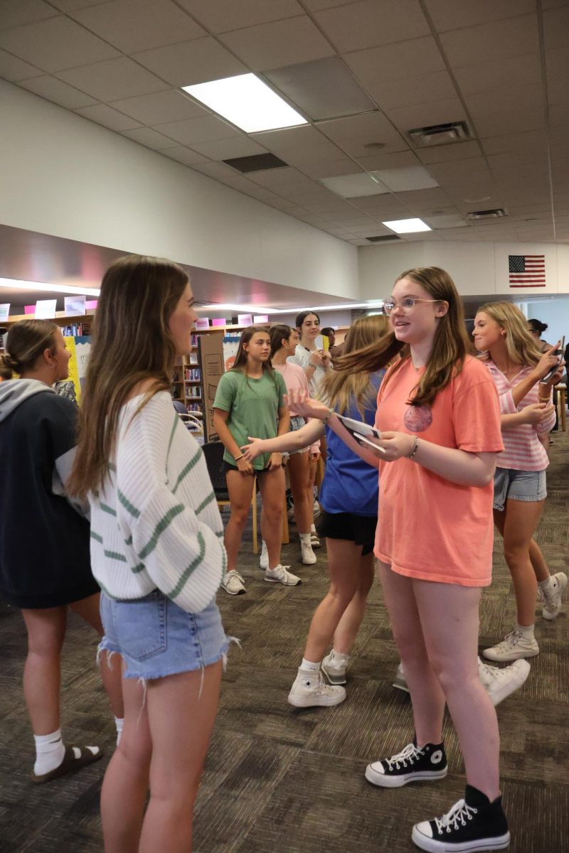 Talking in spanish, sophomore Abby Brown partisipates in the spanish market. On May 20, spanish 3 students held a spanish market in the library. 