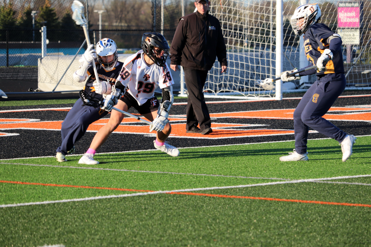 Juking out opponents, sophomore Nathan Fuller makes an attempt on goal. On April 24, the Fenton Tigers beat Farmington United with a score of 11-5. 