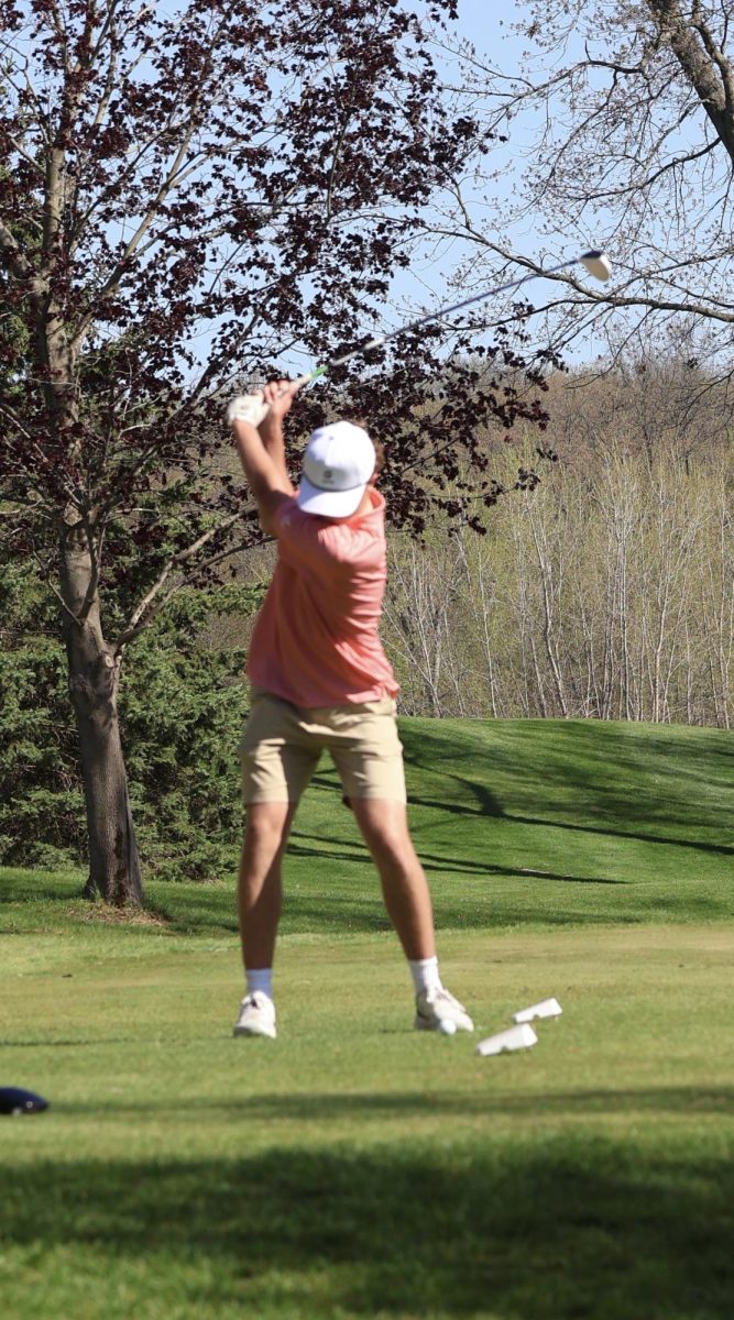 Focusing, junior Keegan McArdle tees off on the tee box. On May 1, the boys varsity golf team played Linden and won with a score of 176-182.