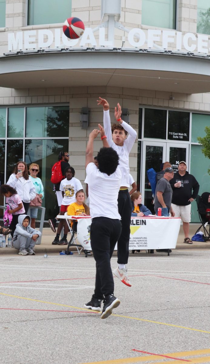 Shooting the ball, sophomore Zack Pearson scores for his team. On June 10, students from FHS on the Michigan Elite basketball team compete in day 1 of a 3v3 Gus Macker tournament.