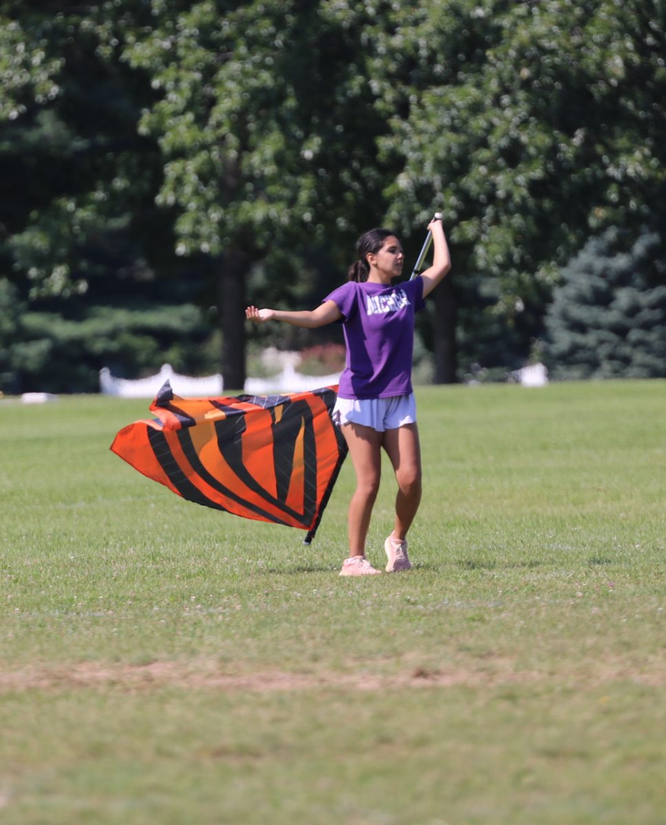 Practicing, senior Sophia Kildee prepares to perform later on in the season. On Aug. 13, the FHS color guard rehearsed for half time. 