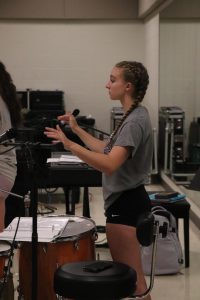 Conducting, sophomore Michaela Wolbert leads the band at practice. On July 8, the band held one of there summer practices at the high school. 