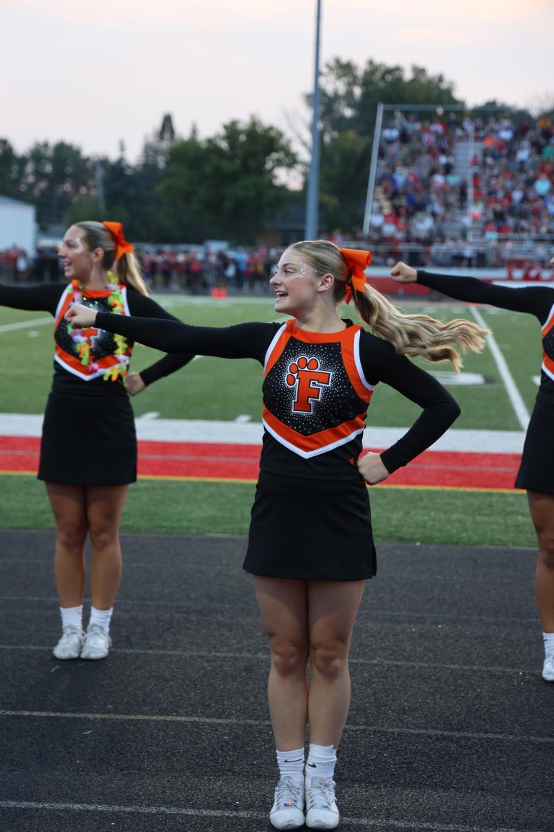 Rooting for the tigers, junior Evie Metcalfe cheers with Fenton. On Sept. 9, the Fenton Tigers beat the Swartz Creek Dragons 39-19.