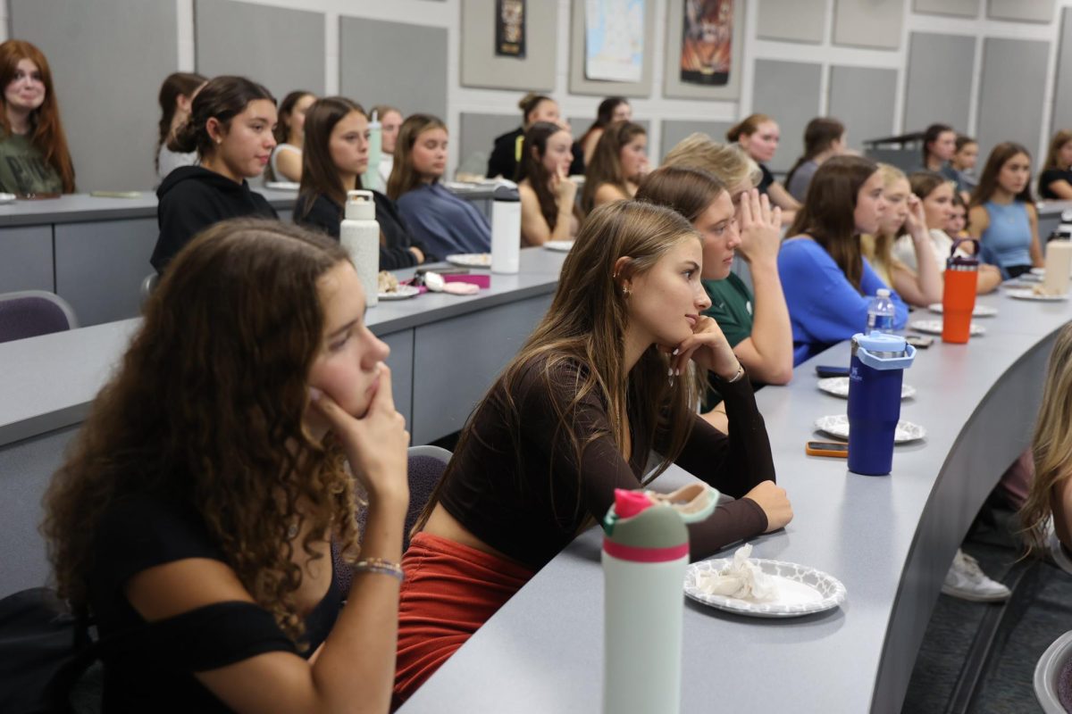 Listening, senior Paige Lafever attends the Key Club meeting. On Sept. 20, Key Club held a meeting with Hungry Howie's pizza for their members. 