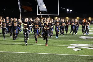 Smiling, seniors Izzy MacCaughan and Olivia Kowalski run the flags across the field. On Sept. 23, the seniors beat the juniors 27-12 in the powderpuff game.