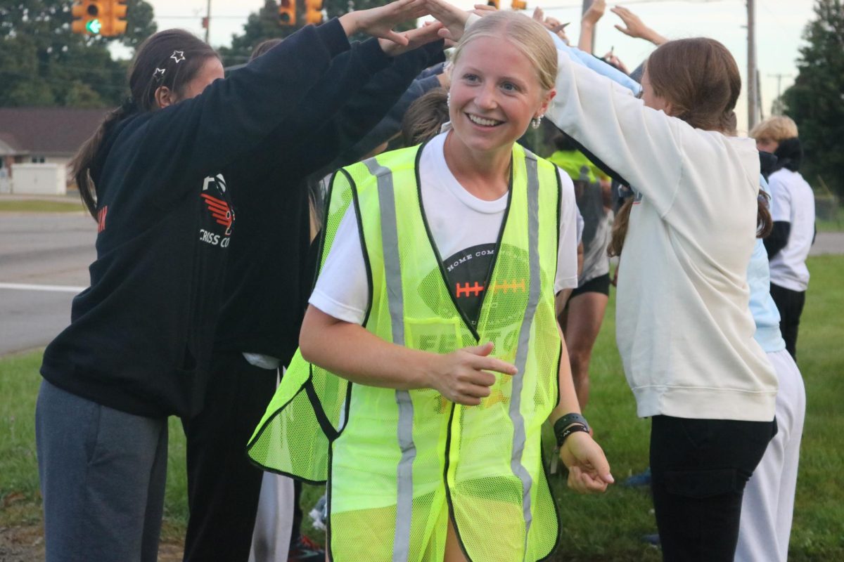 Smiling, Senior Izzy MacCaughan runs through the tunnel finish during the ball run. On Sept. 27 the cross country team had their annual ball run.