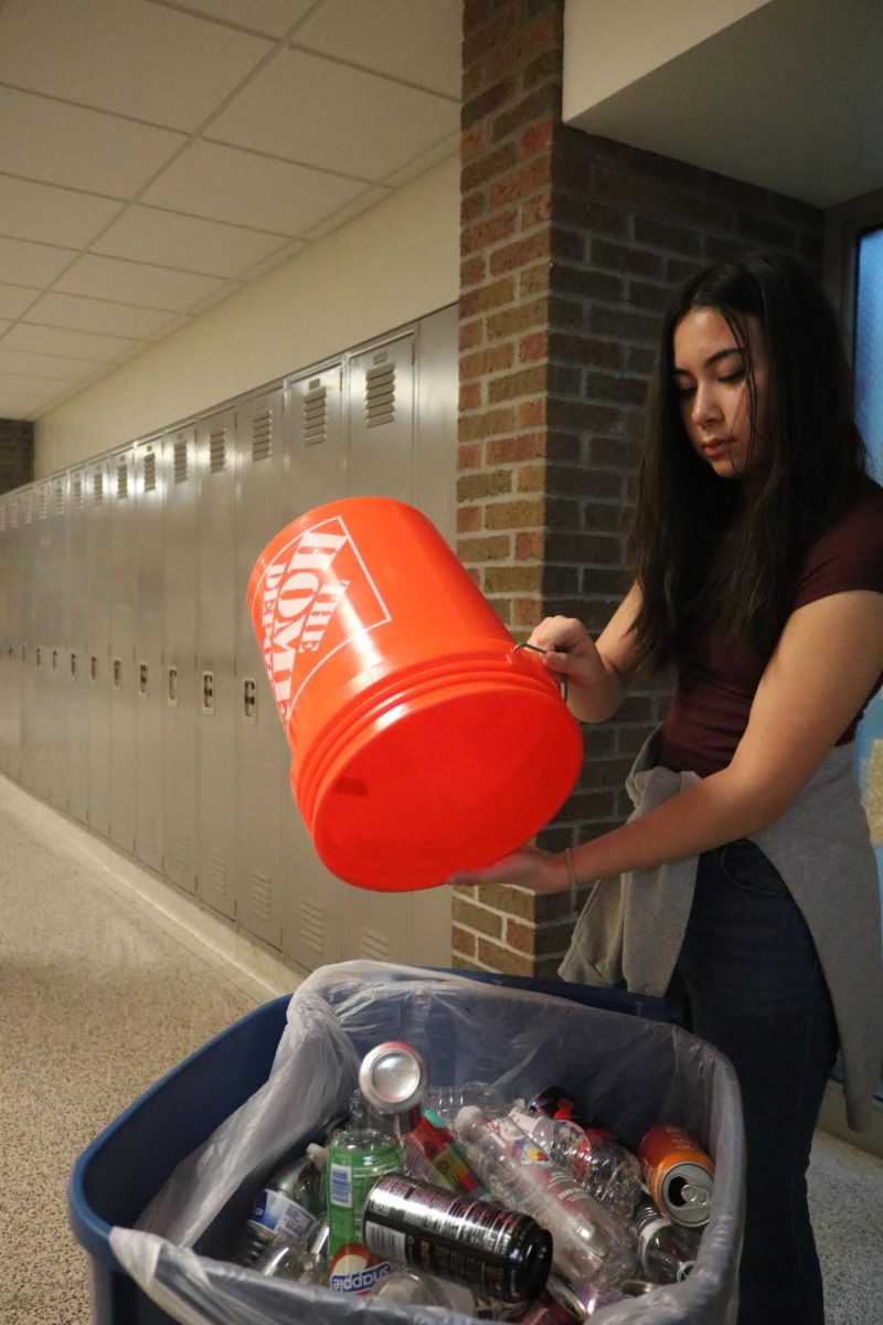 Dumping cans into the recycling bin, sophomore Janessa Bemman helps out ECO club. On Sept. 10th, students help recycle cans.