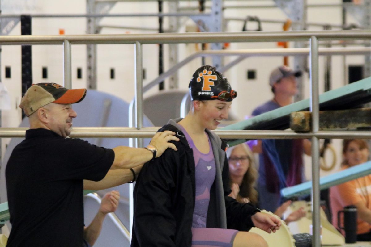 Congratulating, Coach Jones pats Josie Fries on the back. On Sept. 21 Fries helped the FHS swim and dive team get second place in counties when she got fourth place in the 200 individual medley. 