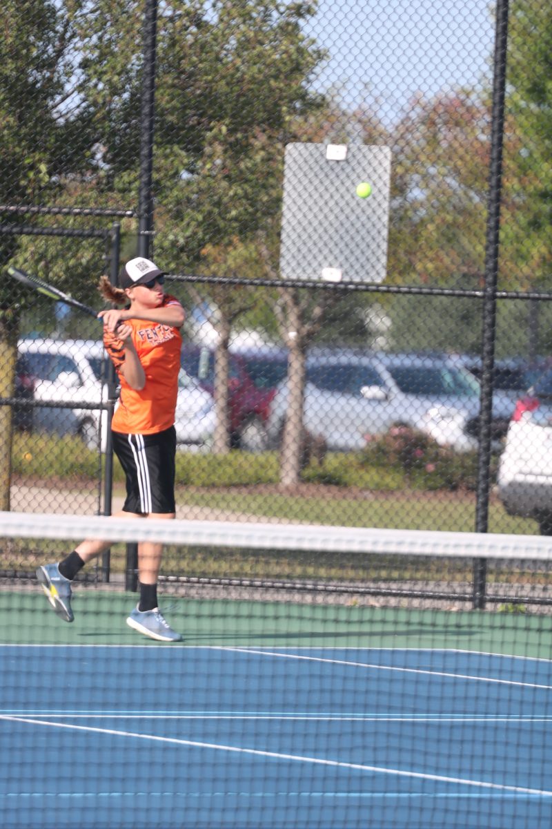 Swinging, junior Jonas Ritchie looks at the ball. On Sept. 10 the FHS boys varsity tennis team played against Clio.