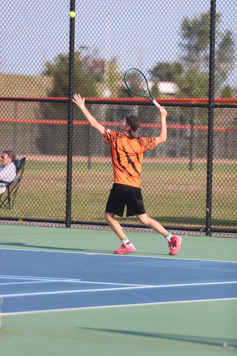 Swinging, senior Joseph Van Every looks at the ball. On Sept. 15, the FHS boys varsity tennis team played against multiple opponents.