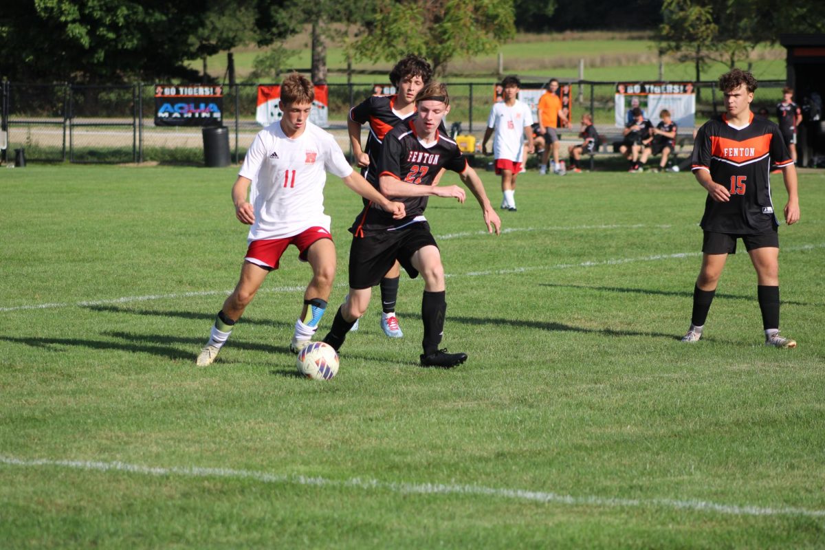 Defending, junior Caleb Wolner attempts to get the ball. On Sept. 9, the JV soccer team played Holly and tied 0-0.