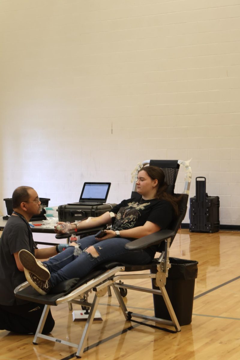 Looking at the instructor, senior Faith Lampe prepares to draw blood. On Sept. 6, FHS held a blood drive for students donate blood. 