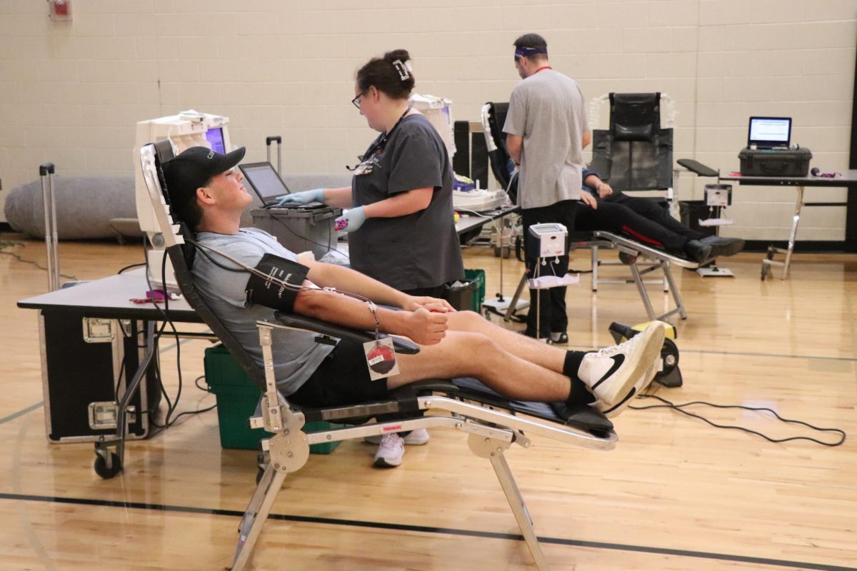 Donating blood, senior Carter Lukasavitz helps save lives by donating a double red. On Sept. 9, NHS held there first annual blood drive in the auxiliary gym.