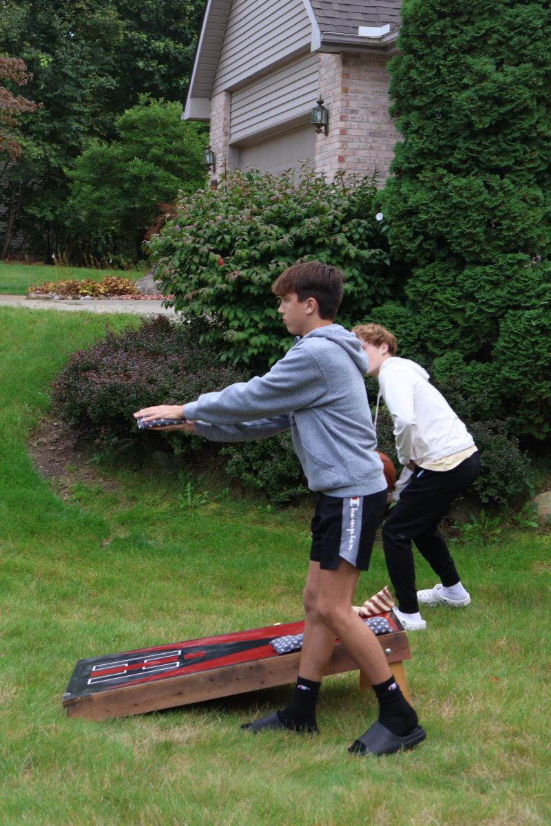 Preparing to throw, Freshman Henry Golembiewski plays corn hole. On Sept. 6, the Fenton cross country team held a pasta party to prepare for their meet the next day.  