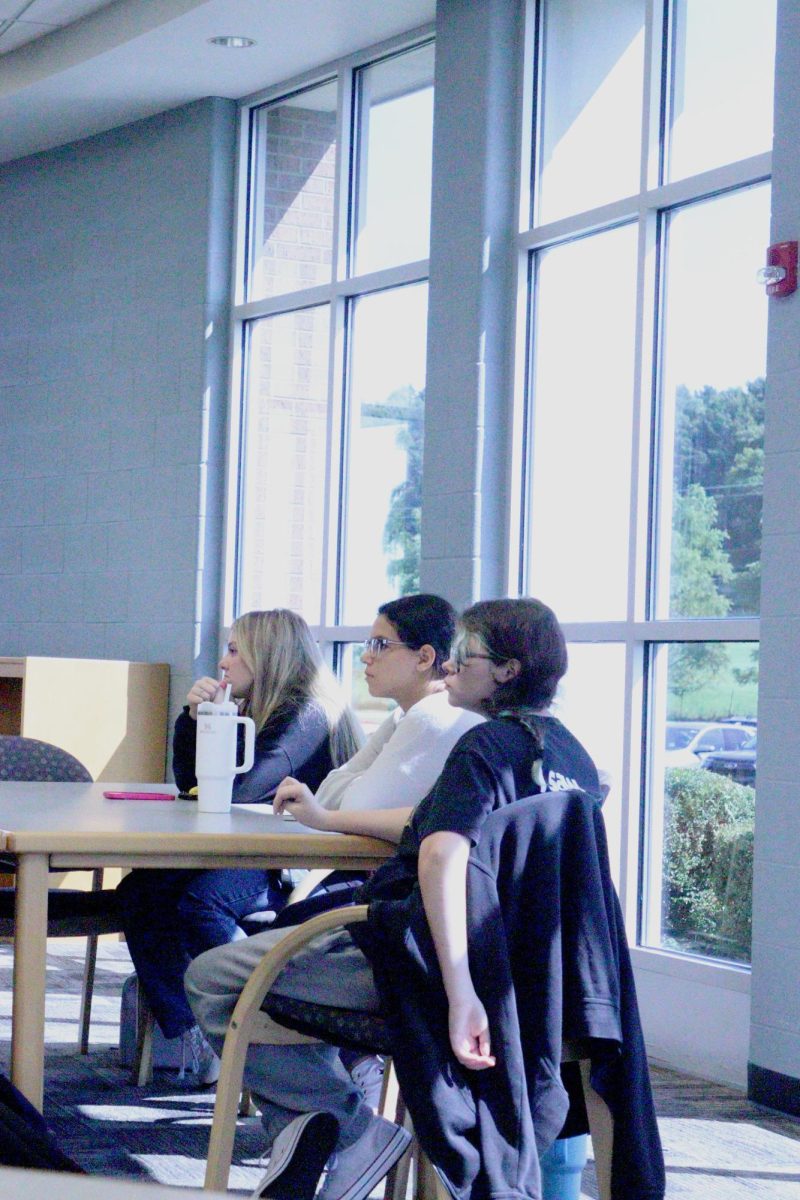 Listening, junior Reese Kildee watches while viewing a lecture. On Sept. 10, FYI gathered in the media center to discuss topics of interest.  