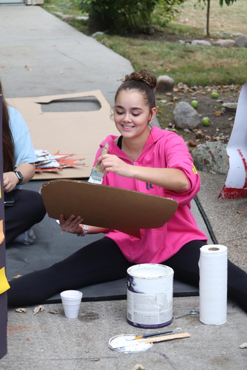 Painting, senior Laila Blackwell helps to decorate the senior float. On Sept. 25, the seniors prepared there float for the homecoming parade. 