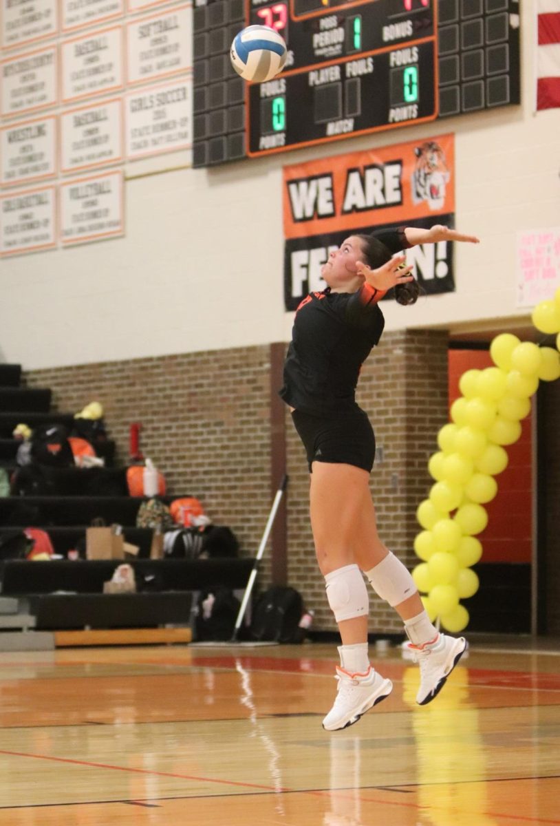 Eyes on the ball, senior Anna Logan serves the ball across the net. On Sept. 18, the varsity volleyball team played in a rival game against Linden and won all three sets.