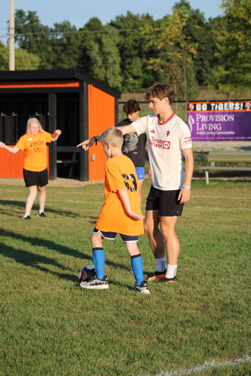 Pointing, senior Jack Oberle plays soccer with his partner. On Sept. 17 the varsity soccer team practiced with the Vipers.
