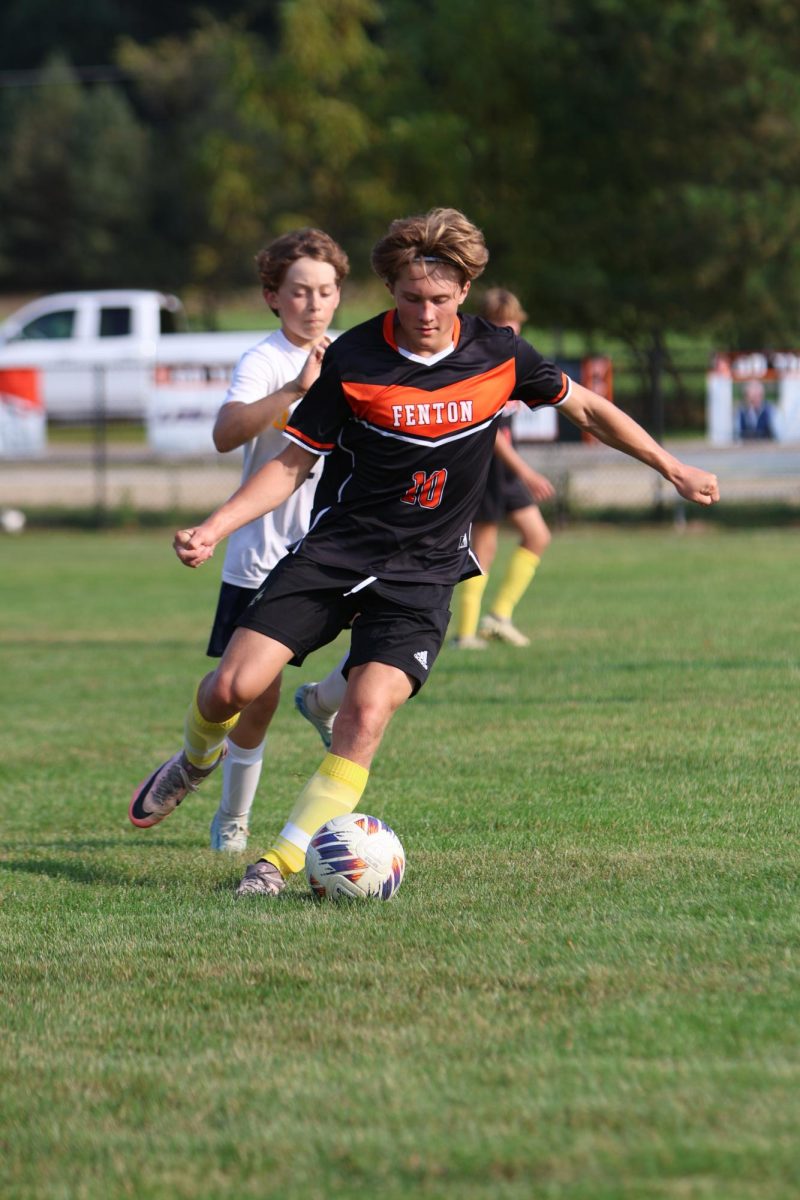 Kicking the ball, sophomore Grant Geiersbach  runs down the field to get ready to score. On Sept. 11, the Jv Boys soccer team won against Owosso 6-1.