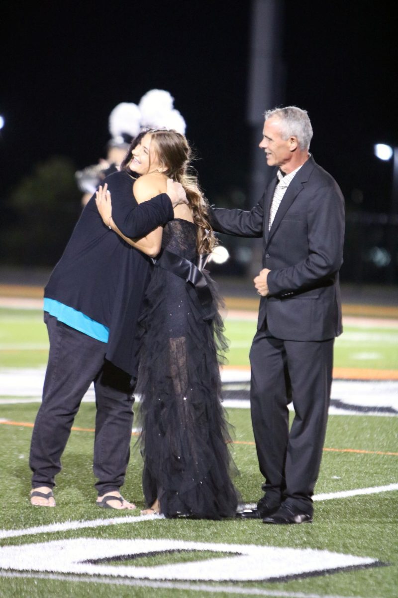 Hugging her mom, senior Paige LeFever wins Homecoming Queen.  On Sept. 28, Homecoming Court walked down the field and voting results were announced. 