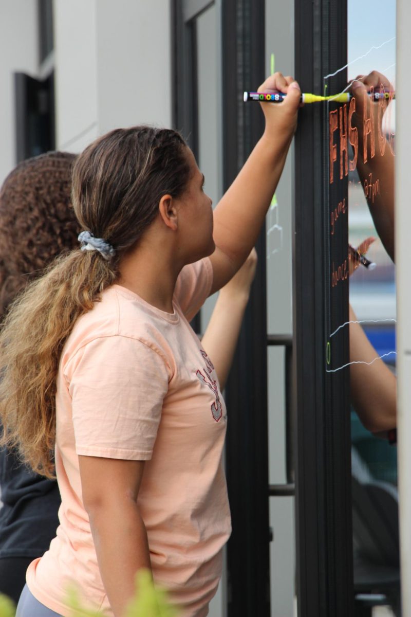 Drawing, sophomore Izzy Ice participates in Paint the Town. On Sept. 22, Student Council prepared for Homecoming.