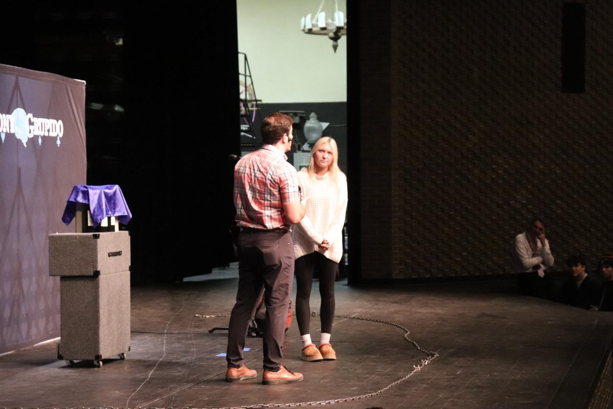 Participating, senior Maddie Knight watches as a magician shows her a trick. On Oct. 15, a assembly was held at FHS to inform students about the importance of mental health while also giving them a magic show.